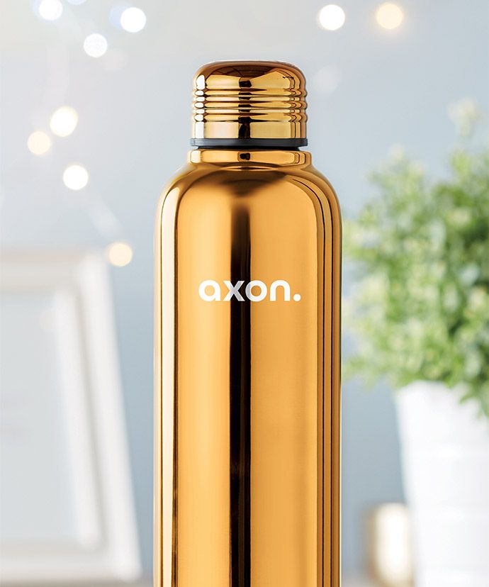 Termo dorado personalizado con una planta al fondo. Regalo publicitario para el invierno.