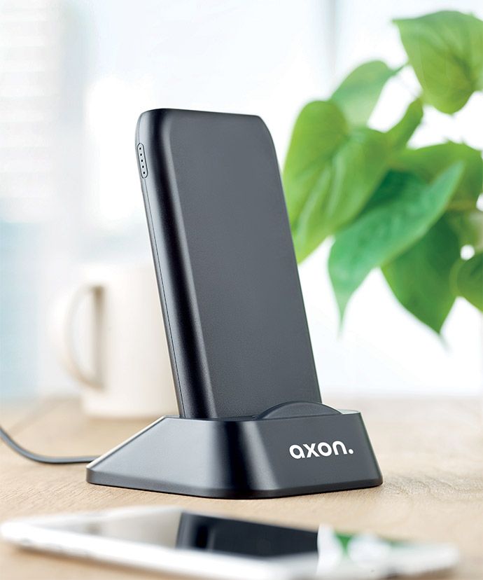 Cargador inalámbrico negro personalizado sobre una mesa. Regalos publicitarios para la oficina.